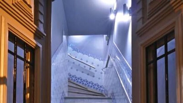 A staircase with a blue tiled wall and wooden doors. - Guest House São Filipe (Faro)