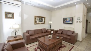 Una sala moderna con un sofá seccional marrón, una mesa de centro de madera y un televisor montado en la pared.
