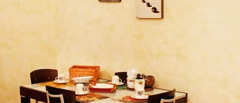 A dining area with a table set for four, chairs, and a few decorative items.