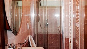 Un baño con un lavamanos grande, un espejo, una ducha y un inodoro.