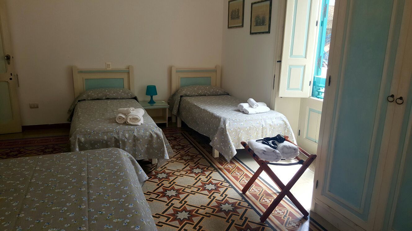 Une chambre d’hôtel avec deux lits, une petite table avec une lampe et une chaise.