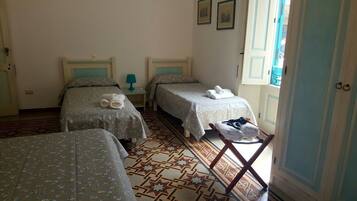 Une chambre d’hôtel avec deux lits, une petite table avec une lampe et une chaise.