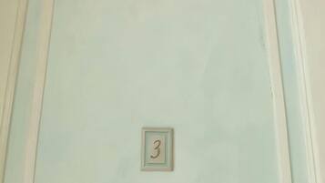 A door with a decorative molding and a small number plaque.