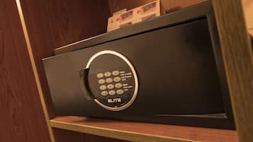 A black safe with a keypad, placed on a wooden shelf.