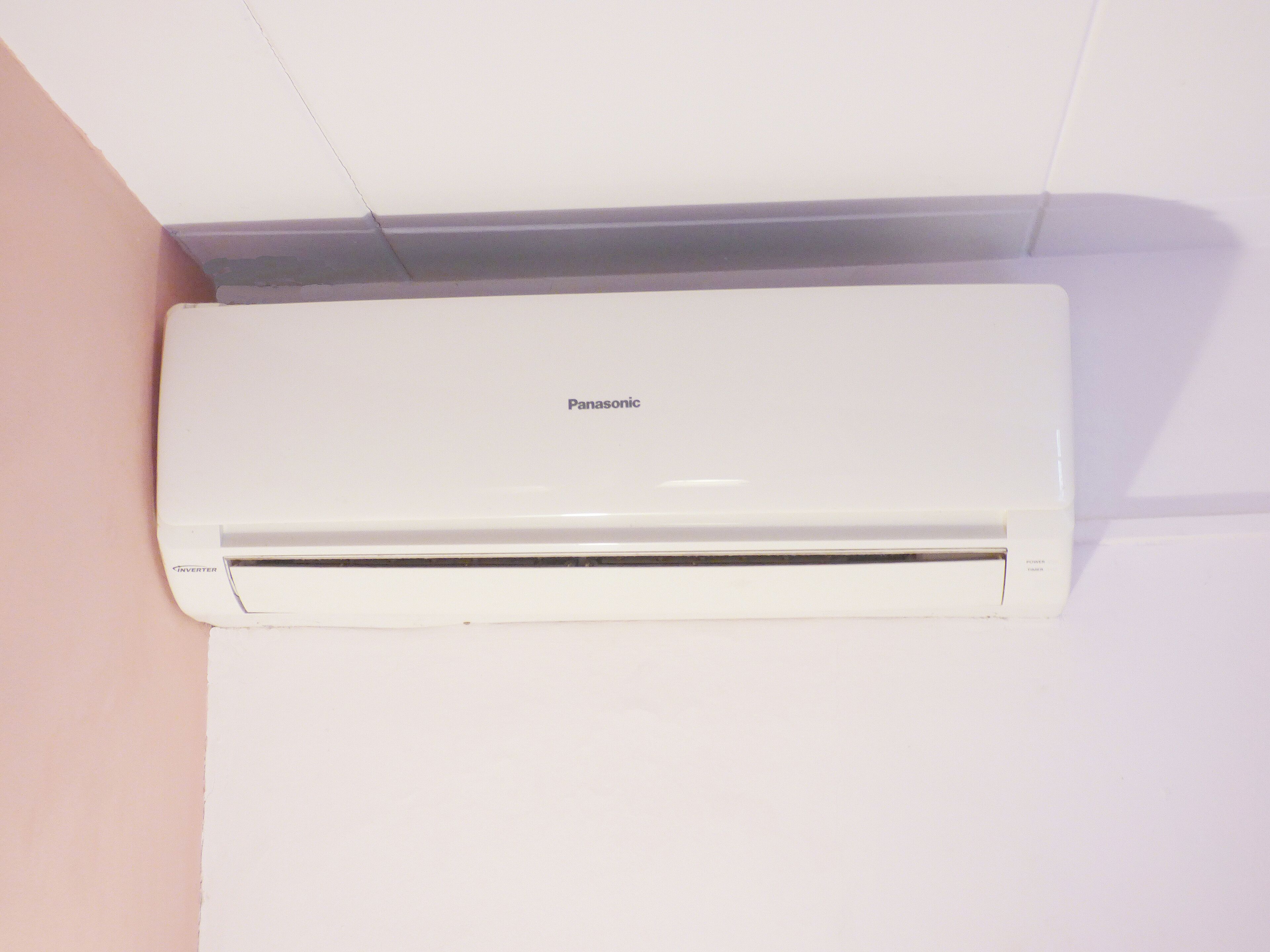 A white Panasonic inverter air conditioner mounted on a wall.