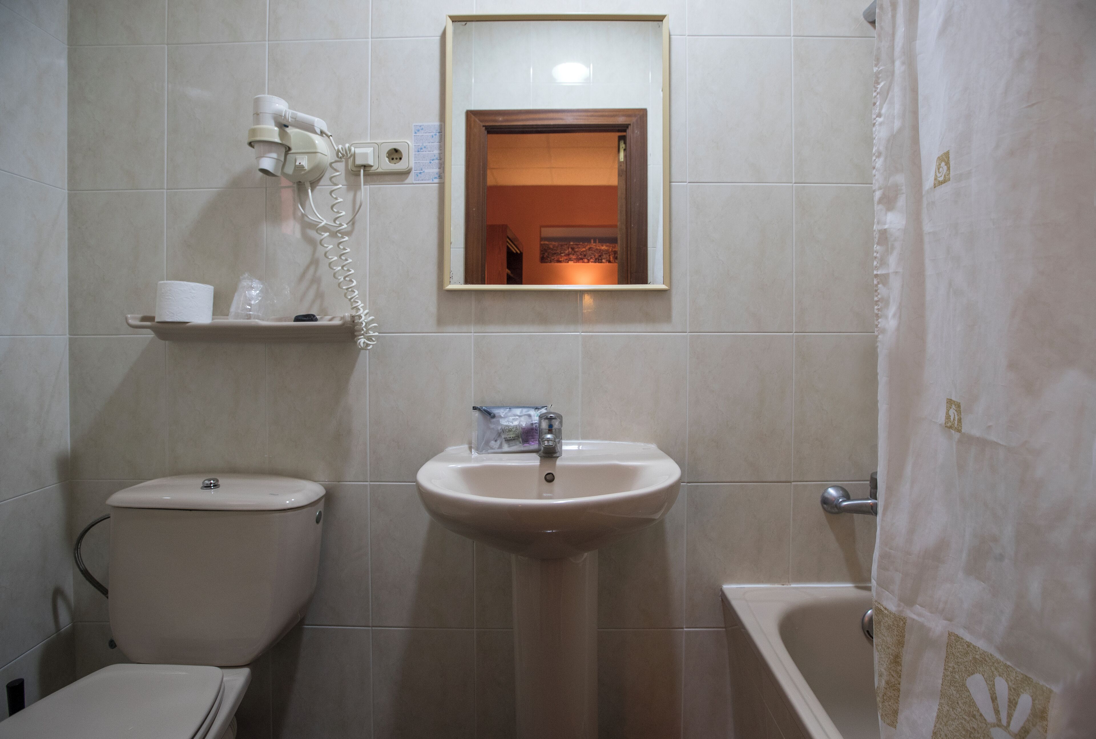 Een badkamer met toilet, wastafel en bad.