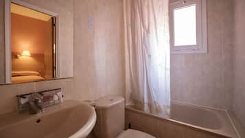 A bathroom with a sink, toilet, and bathtub.