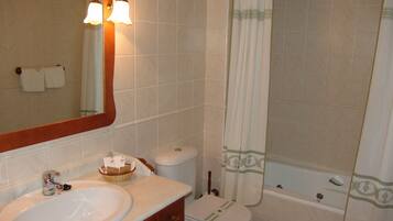 Un baño con lavamanos, inodoro y bañera.