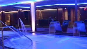 A modern spa area with a heated floor, glass doors, and a digital display.
