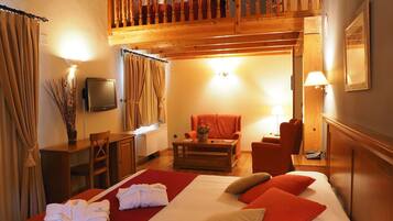 Una habitación de hotel con cama, escritorio, silla, televisor y balcón.