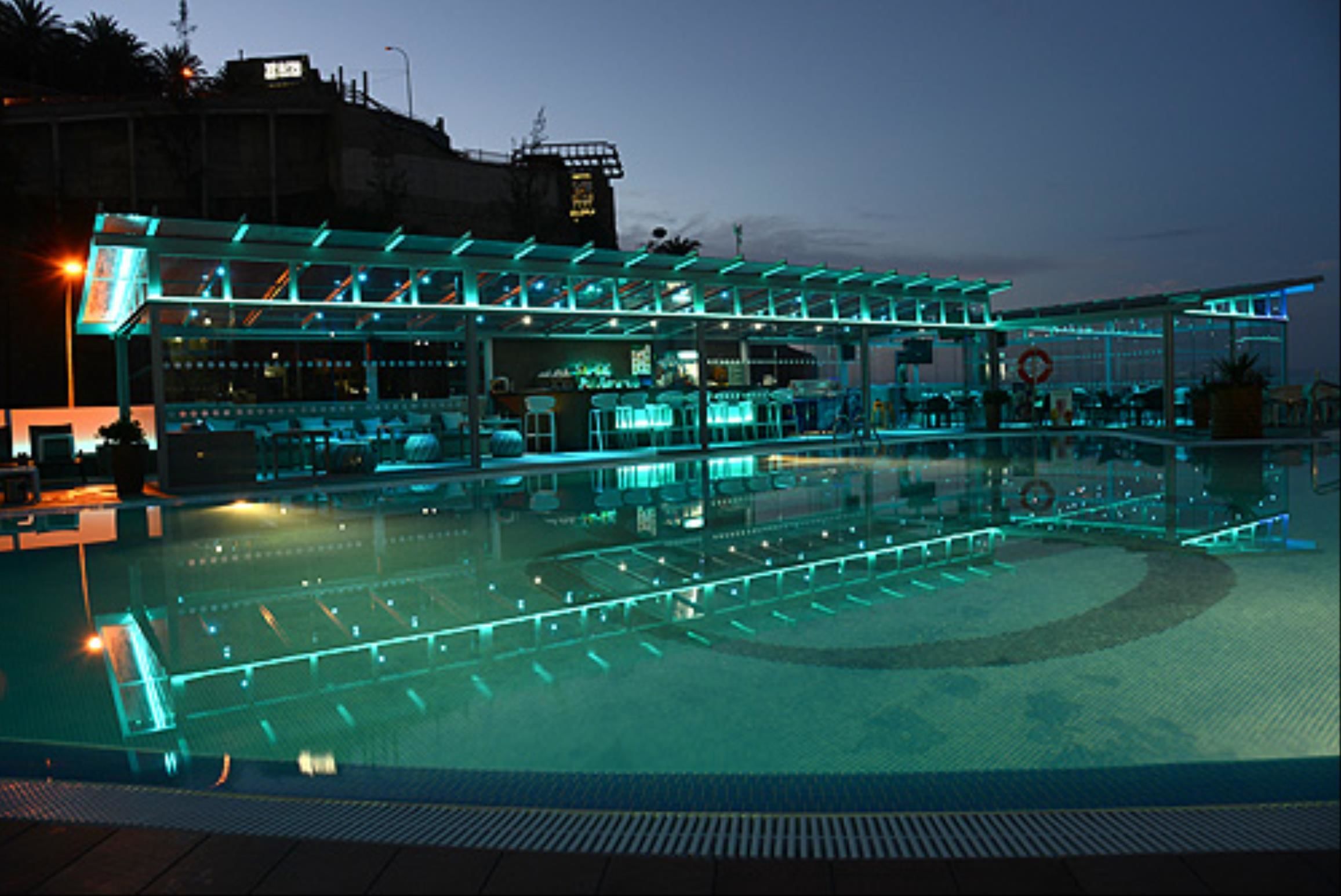 A pool area with a covered seating area and a bar.