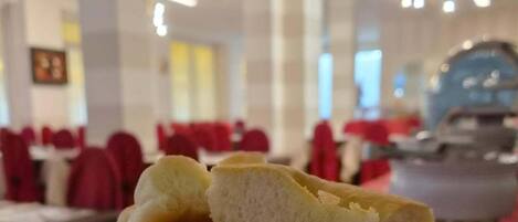 Un montón de panecillos en un comedor con mesas y sillas.
