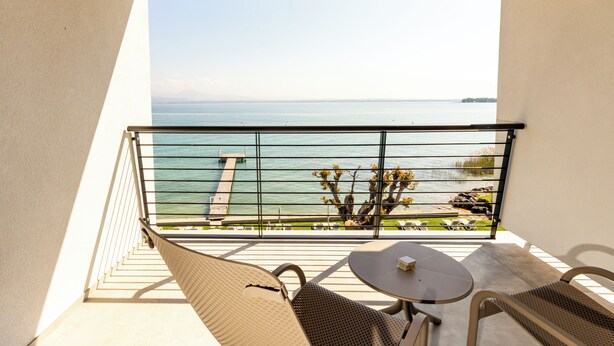 Un balcón con vistas al mar, una mesa y sillas.