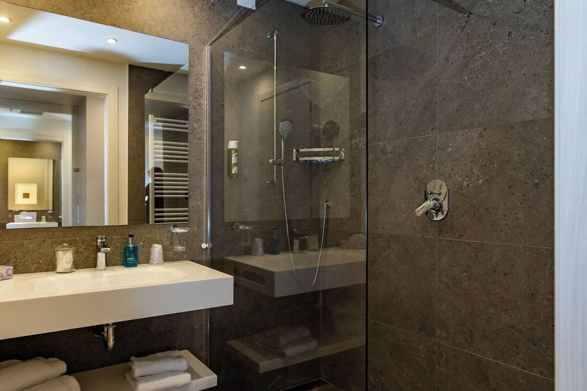 superior room, partial lake view | bathroom | shower, free toiletries, hair dryer, bathrobes