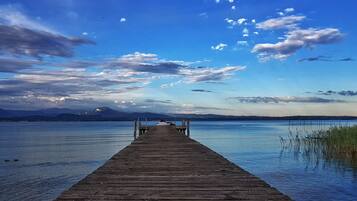 A wooden pier extending into calm water with a clear sky above.