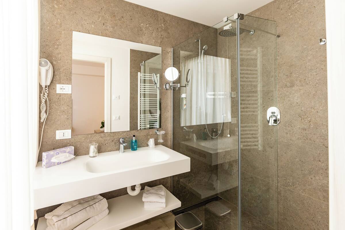 junior suite, lake view | bathroom | shower, free toiletries, hair dryer, bathrobes