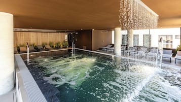 Una piscina techada, una piscina al aire libre de temporada, sombrillas