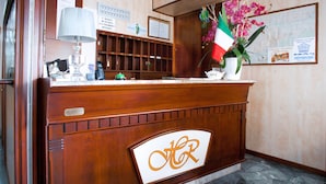 Un comptoir d’accueil en bois sur lequel est apposée une enseigne indiquant « Hôtel Riviera ».