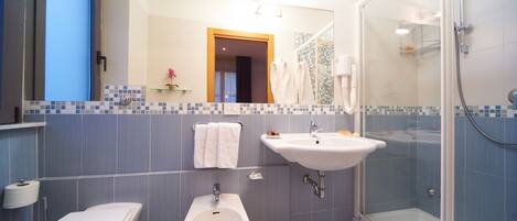 Ein modernes Badezimmer mit integriertem Bidet, Toilette, Waschbecken und einer Duschkabine.