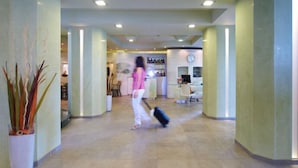 A spacious lobby with a central corridor, a reception area, and a dining area. - Hotel Sirio (Camaiore)