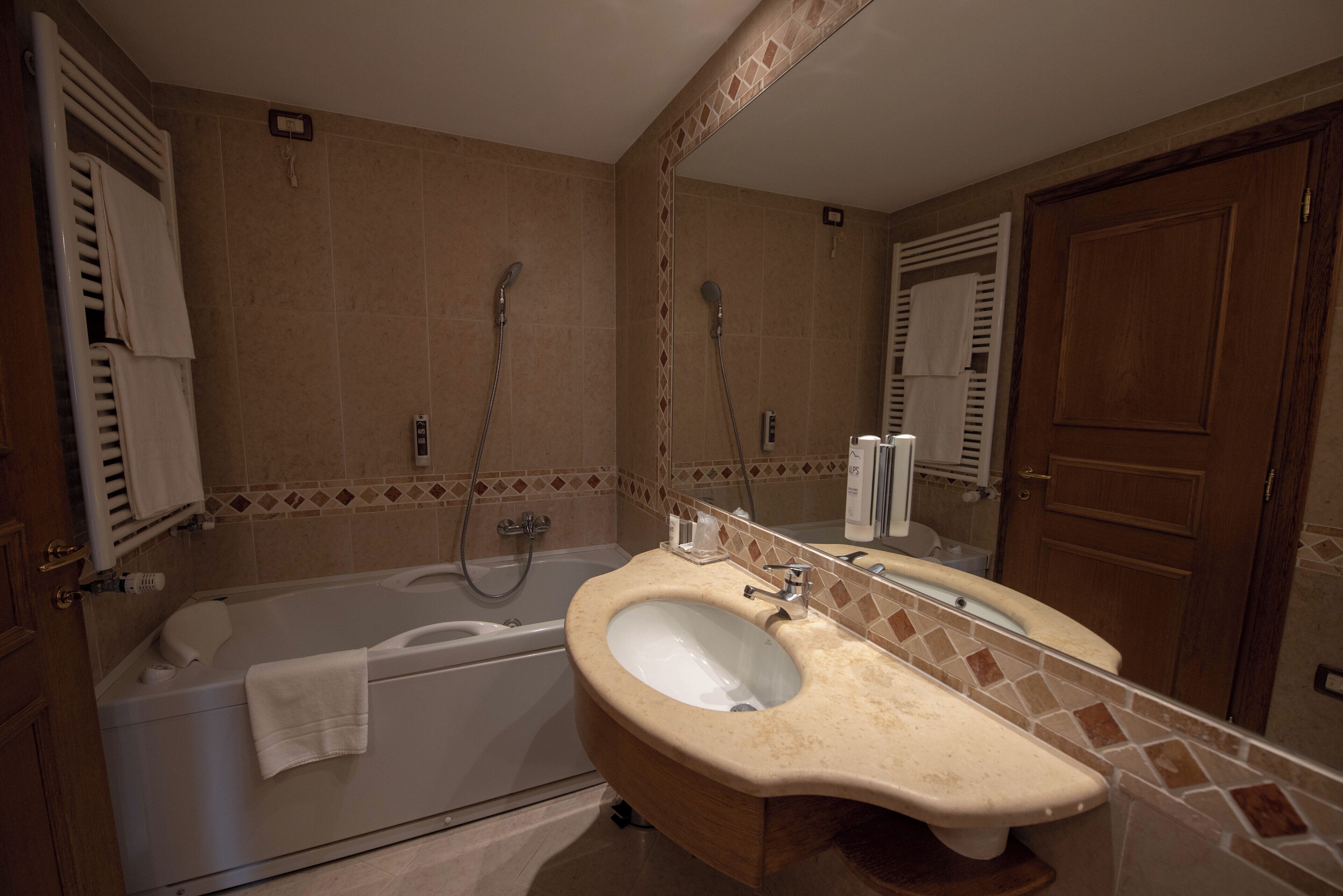 Une salle de bain avec une baignoire, un lavabo et un miroir.