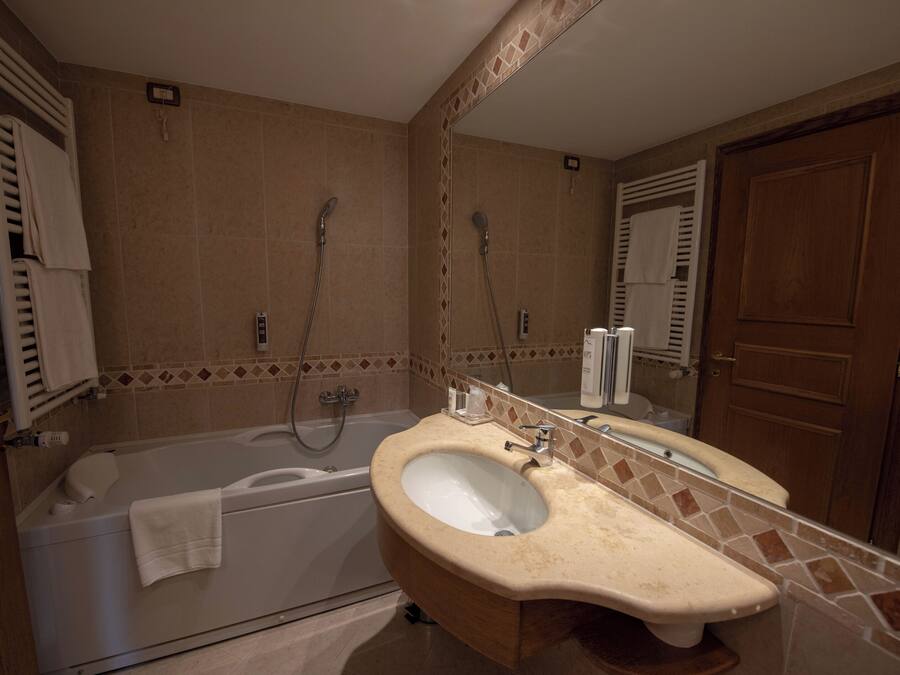 Une salle de bain avec une baignoire, un lavabo et un miroir.