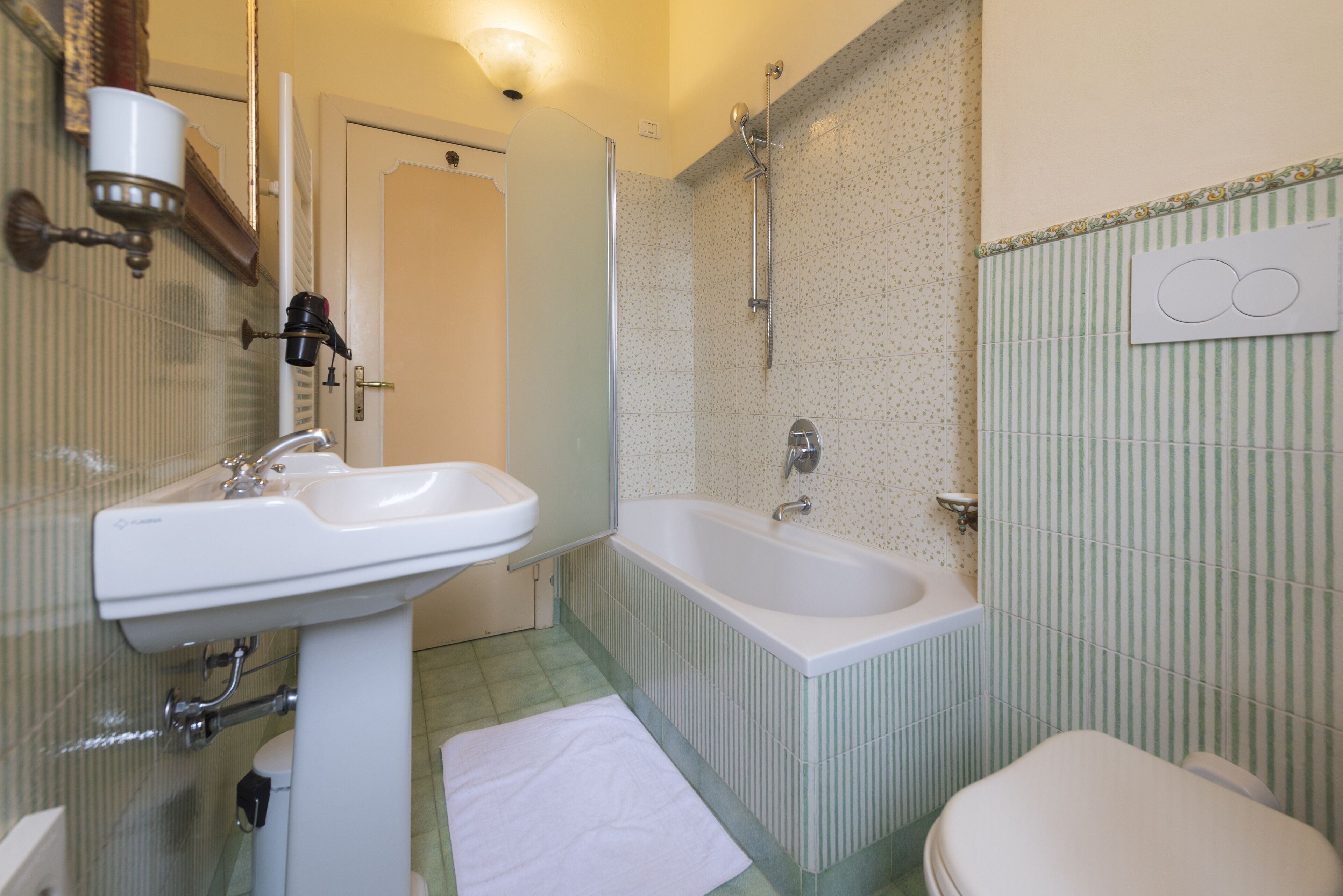 Ein Badezimmer mit Waschbecken, Badewanne, Toilette und Dusche.