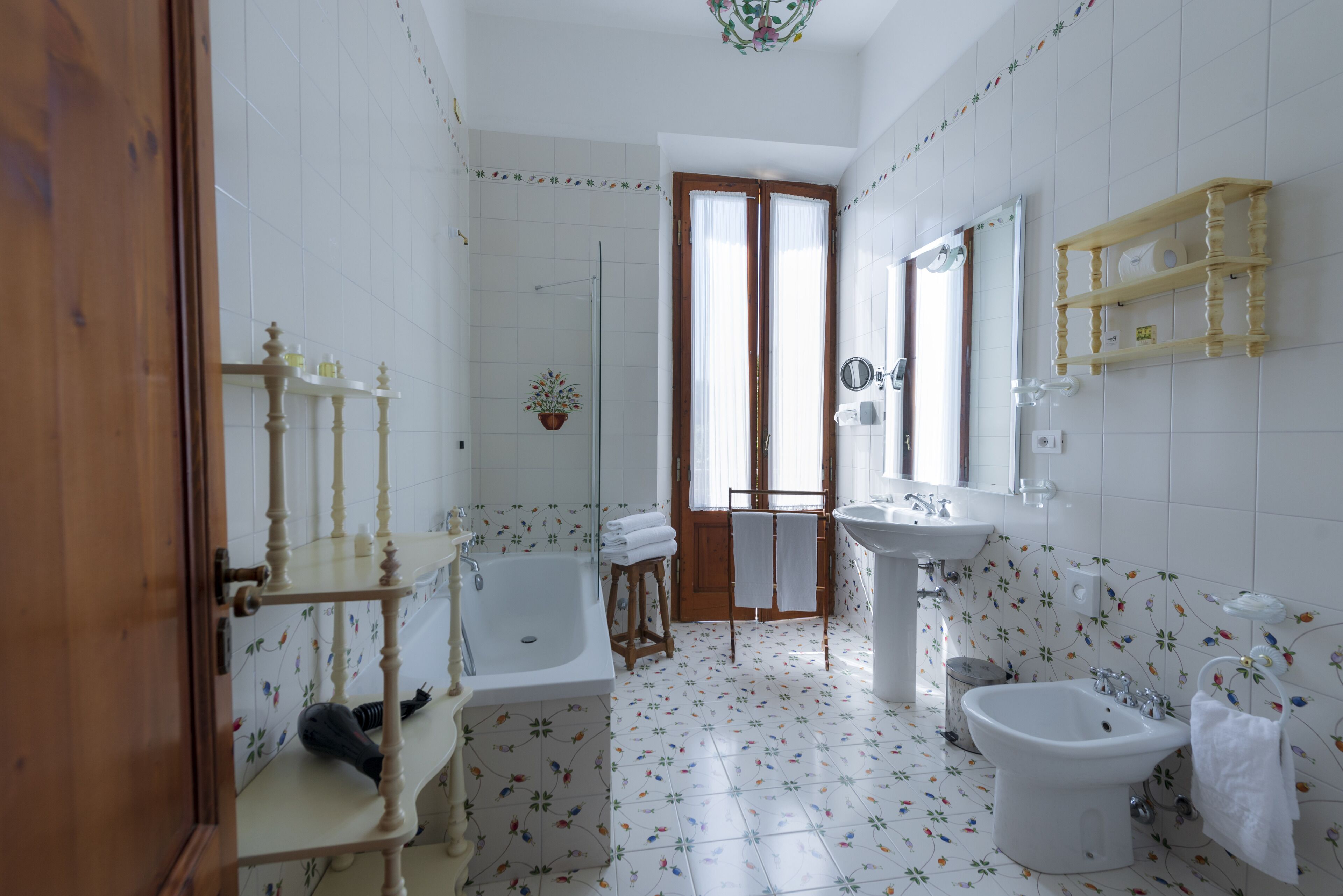 Un baño con bañera, lavamanos, lavavaterinas y zona de ducha.