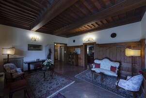 Un salón amplio con techo de madera, chimenea y una zona de estar acogedora con sofá y sillones.
