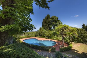 Una piscina al aire libre de temporada, sombrillas
