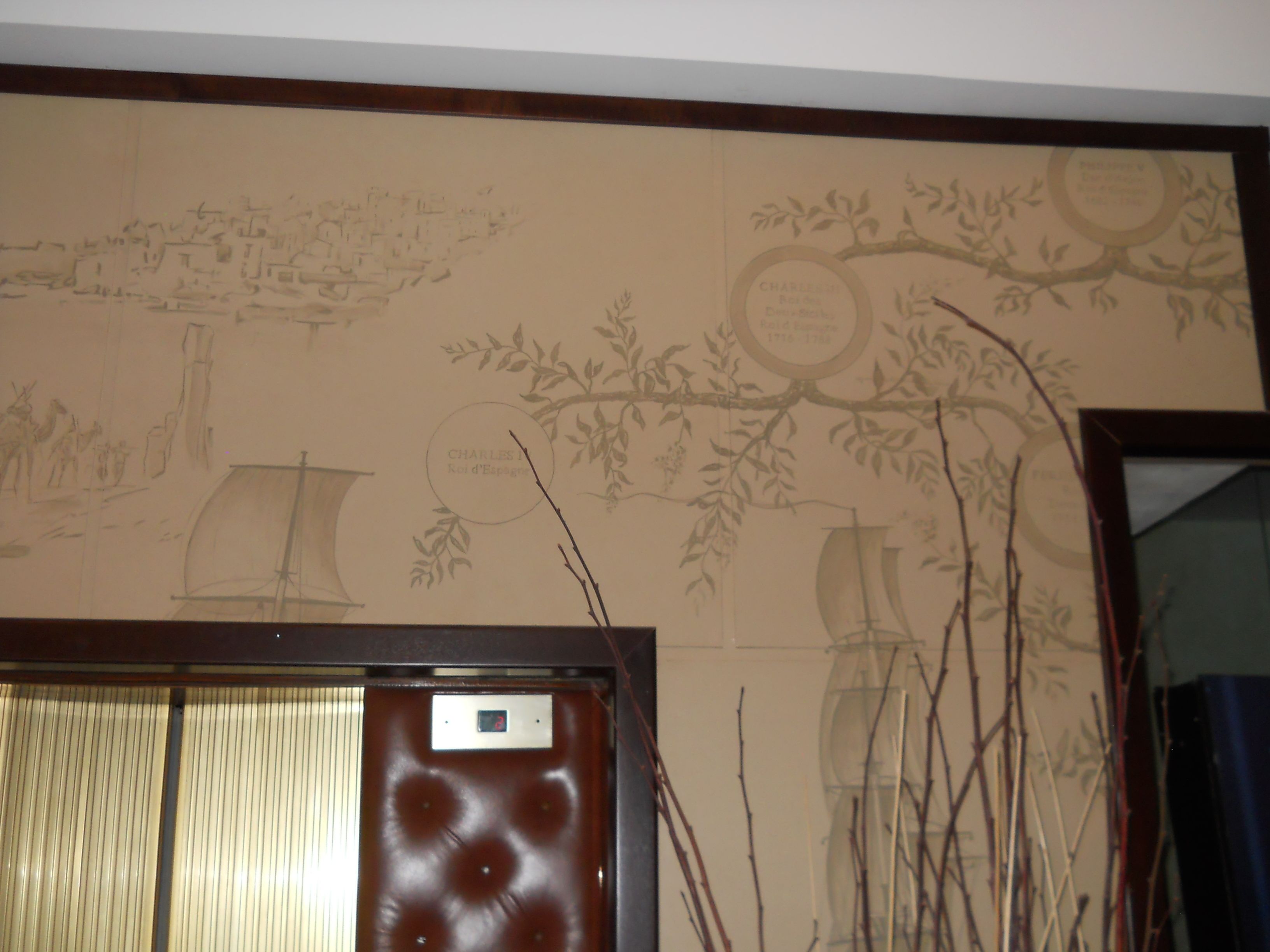A room with a large mirror and a wall with a mural.