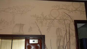 A room with a large mirror and a wall with a mural.