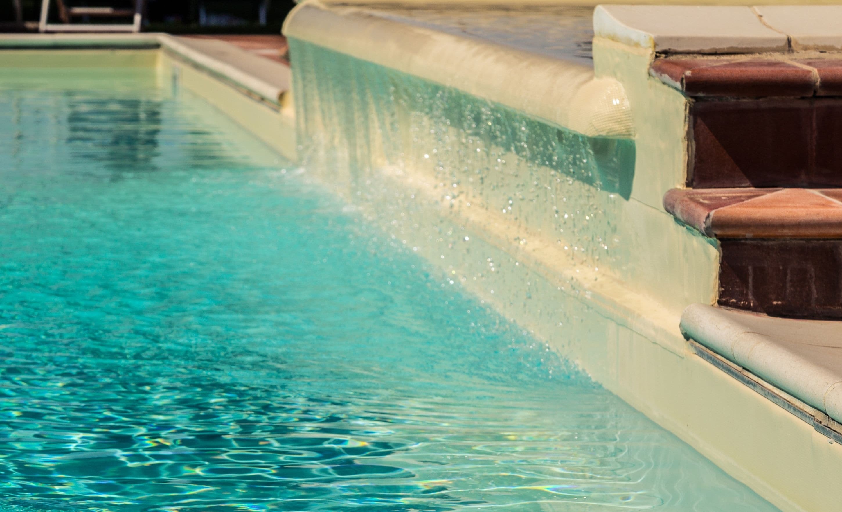 Una piscina con agua cristalina y un elemento acuático.