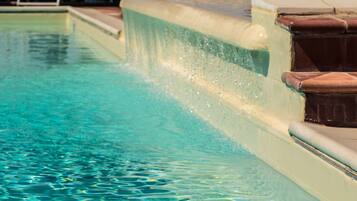 Una piscina con agua cristalina y un elemento acuático.