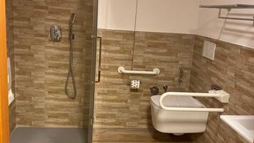 A modern bathroom with a shower, toilet, and bathtub.