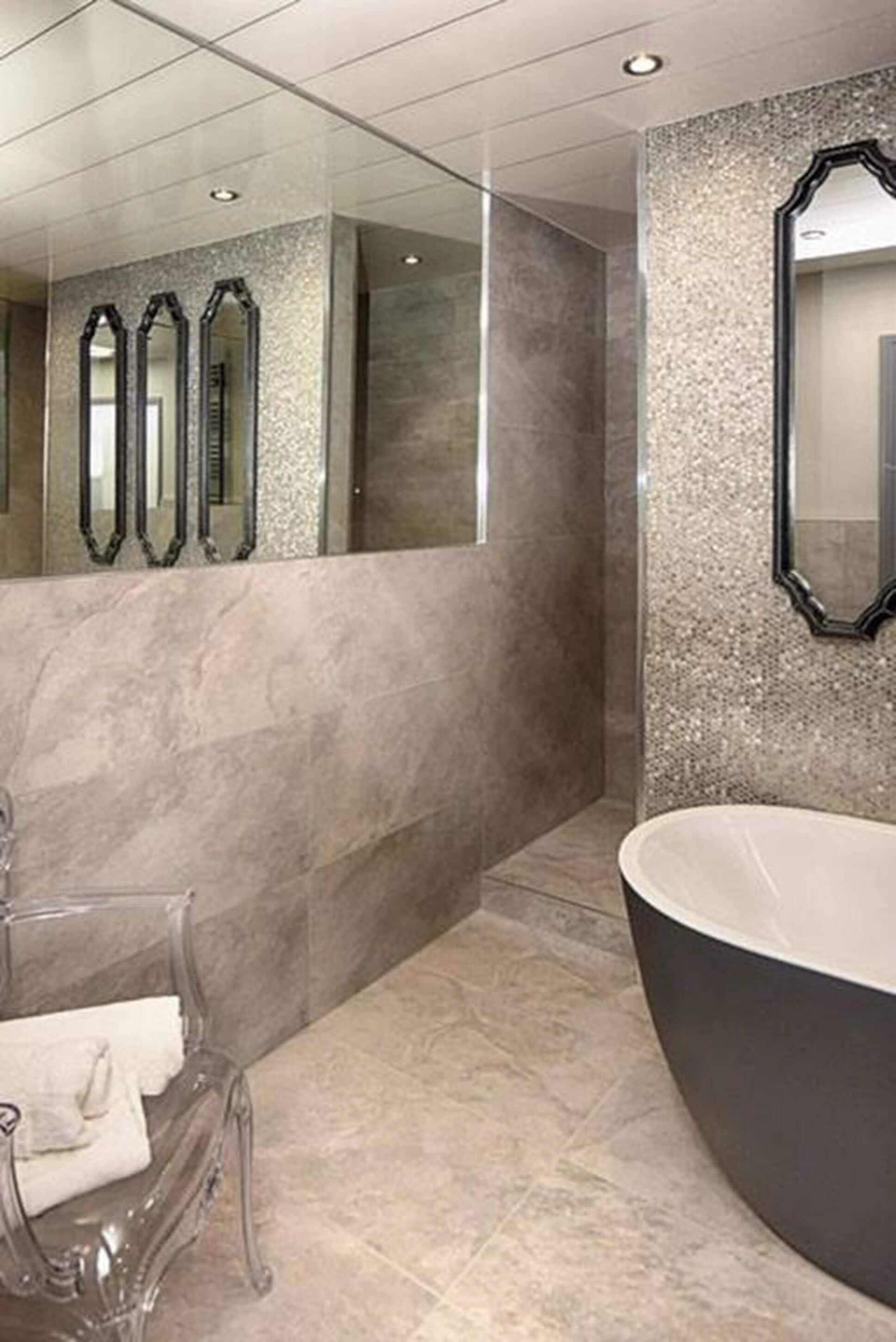 A modern bathroom with a large bathtub, a glass shower enclosure, and a marble wall.