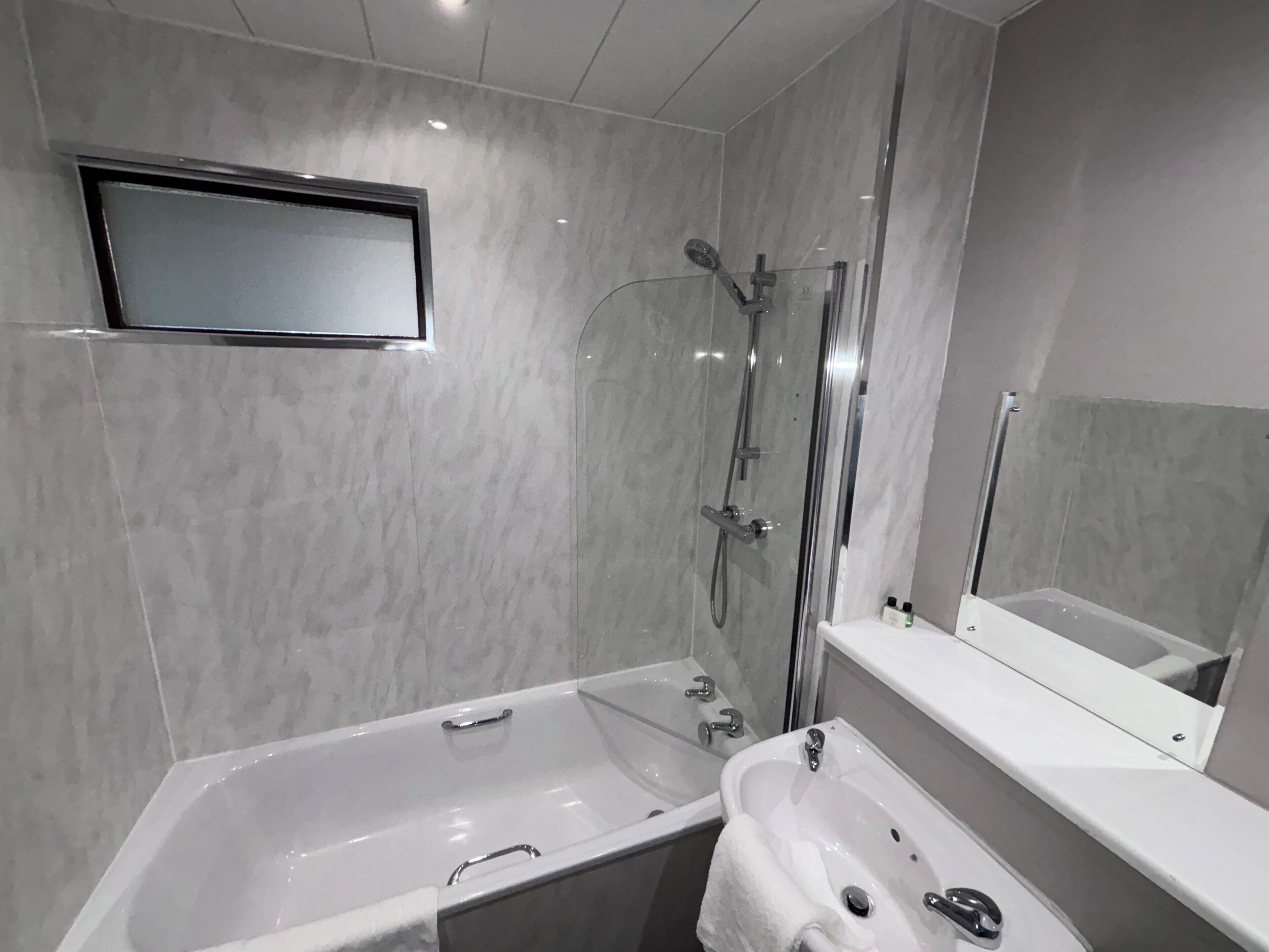 Un baño moderno con bañera, lavamanos y ducha.