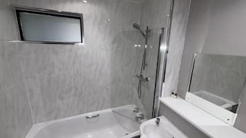Un baño moderno con bañera, lavamanos y ducha.