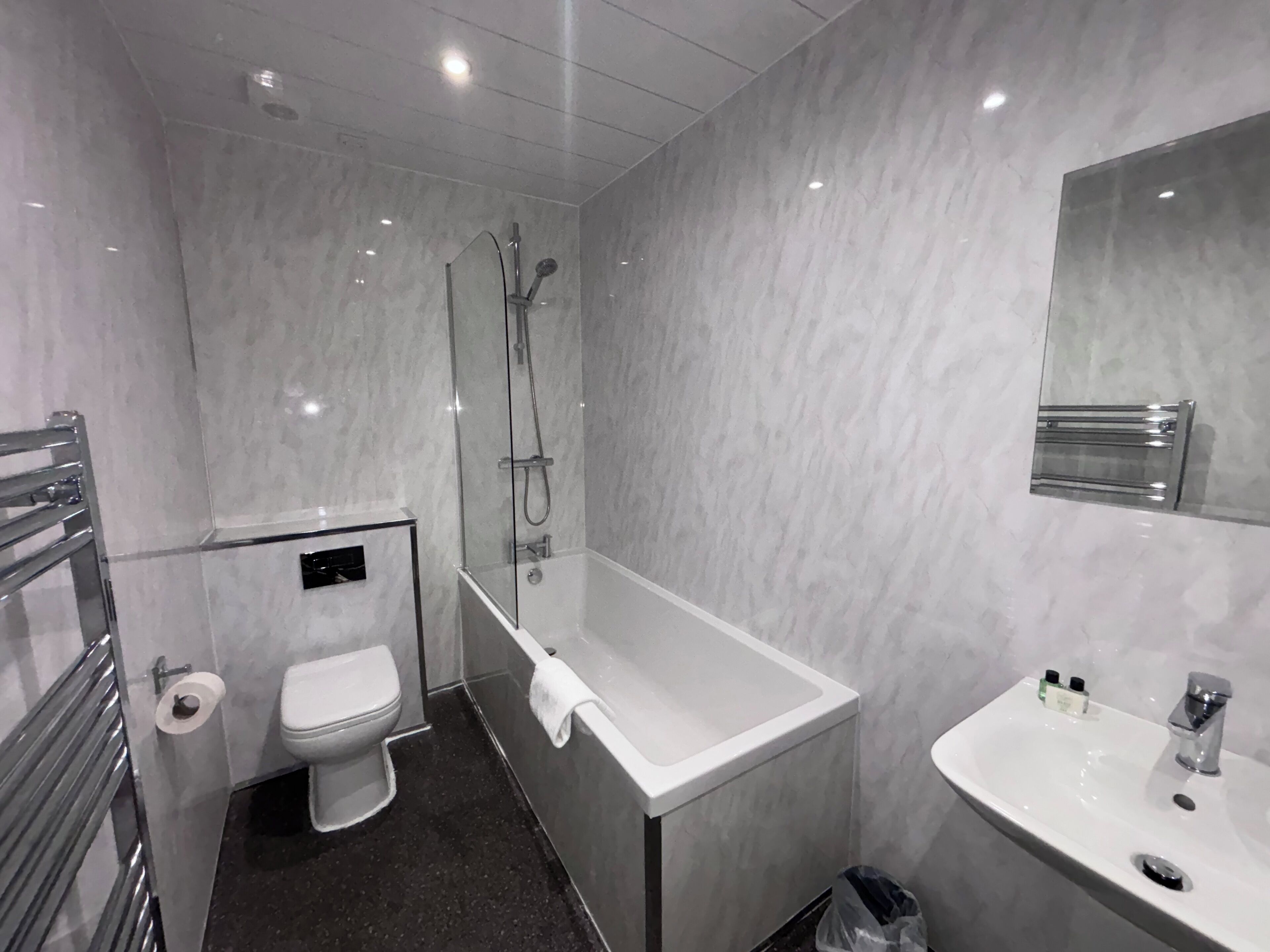 Un bany modern amb vàter, banyera i un lavabo.