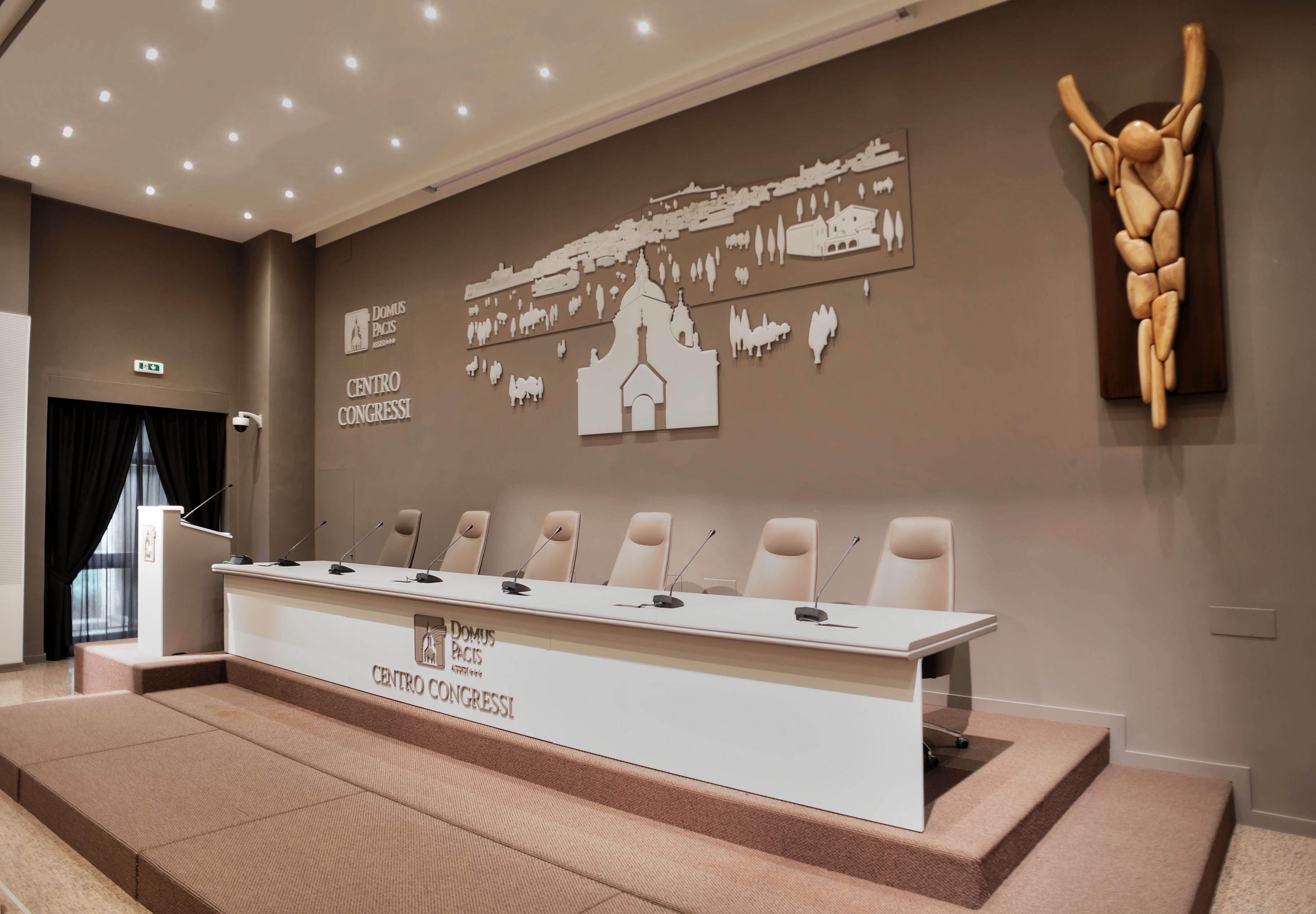A conference room with a long table, six chairs, and a podium.