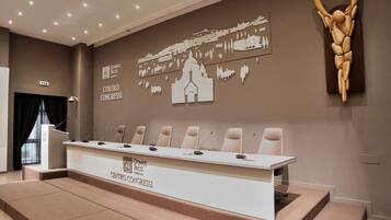 A conference room with a long table, six chairs, and a podium.