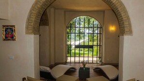 Una habitación con un amplio ventanal de arco, dos sofás y una mesita.