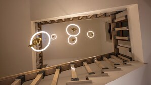 A staircase with a modern design, featuring a wooden handrail and marble steps. - Hotel Moderno (Assisi)