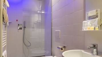 Un baño moderno con ducha de vidrio, inodoro y lavamanos.