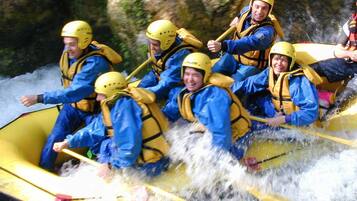 A group of people in a yellow raft navigating a river.