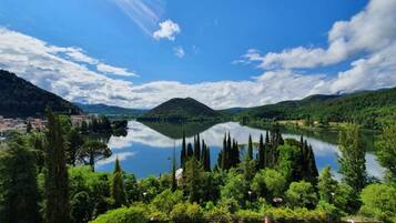 A lake surrounded by hills, with a town in the foreground and a mountain in the background.