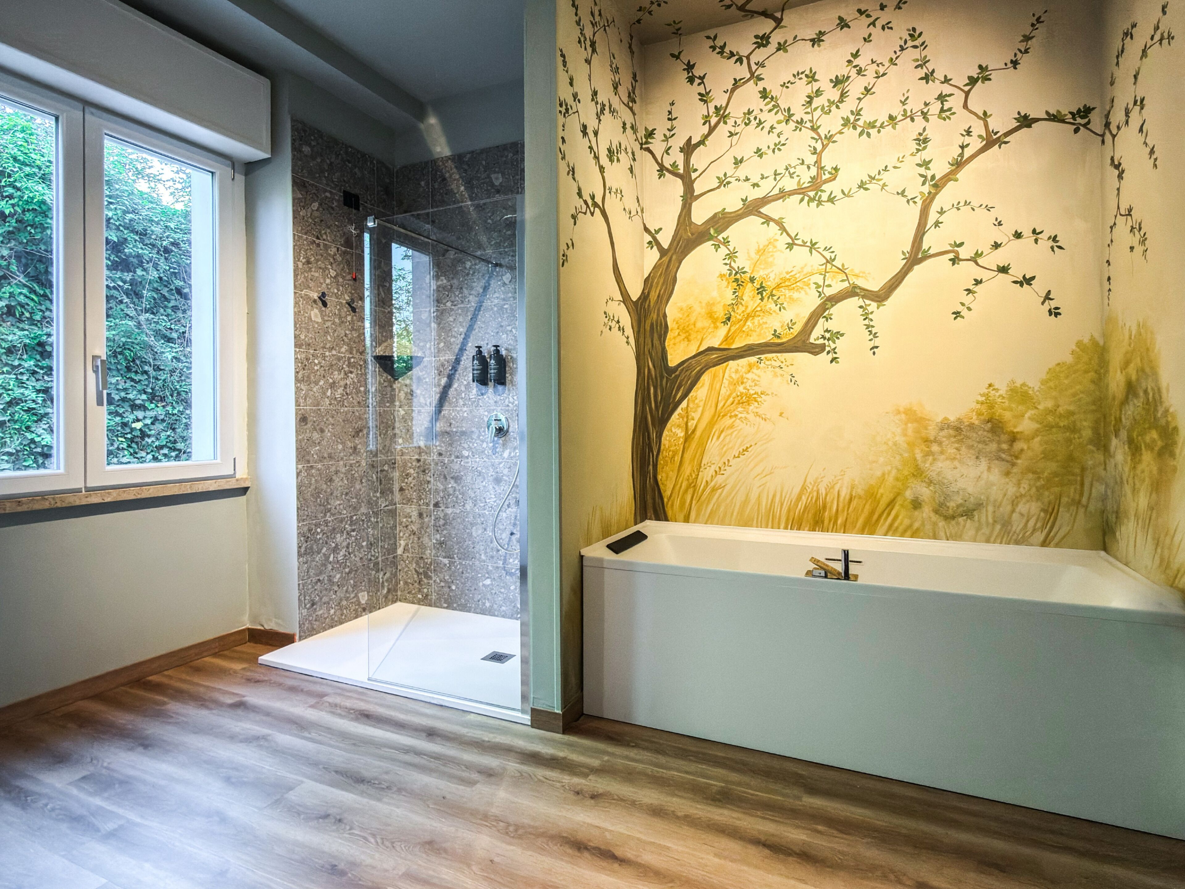 Un baño con ducha, bañera y un ventanal grande.