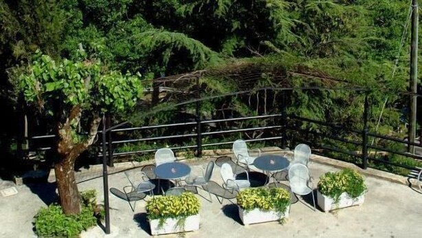 A terrace with outdoor seating and a view of a lake and mountains. - Hotel Del Lago 1934 & SPA (Terni)