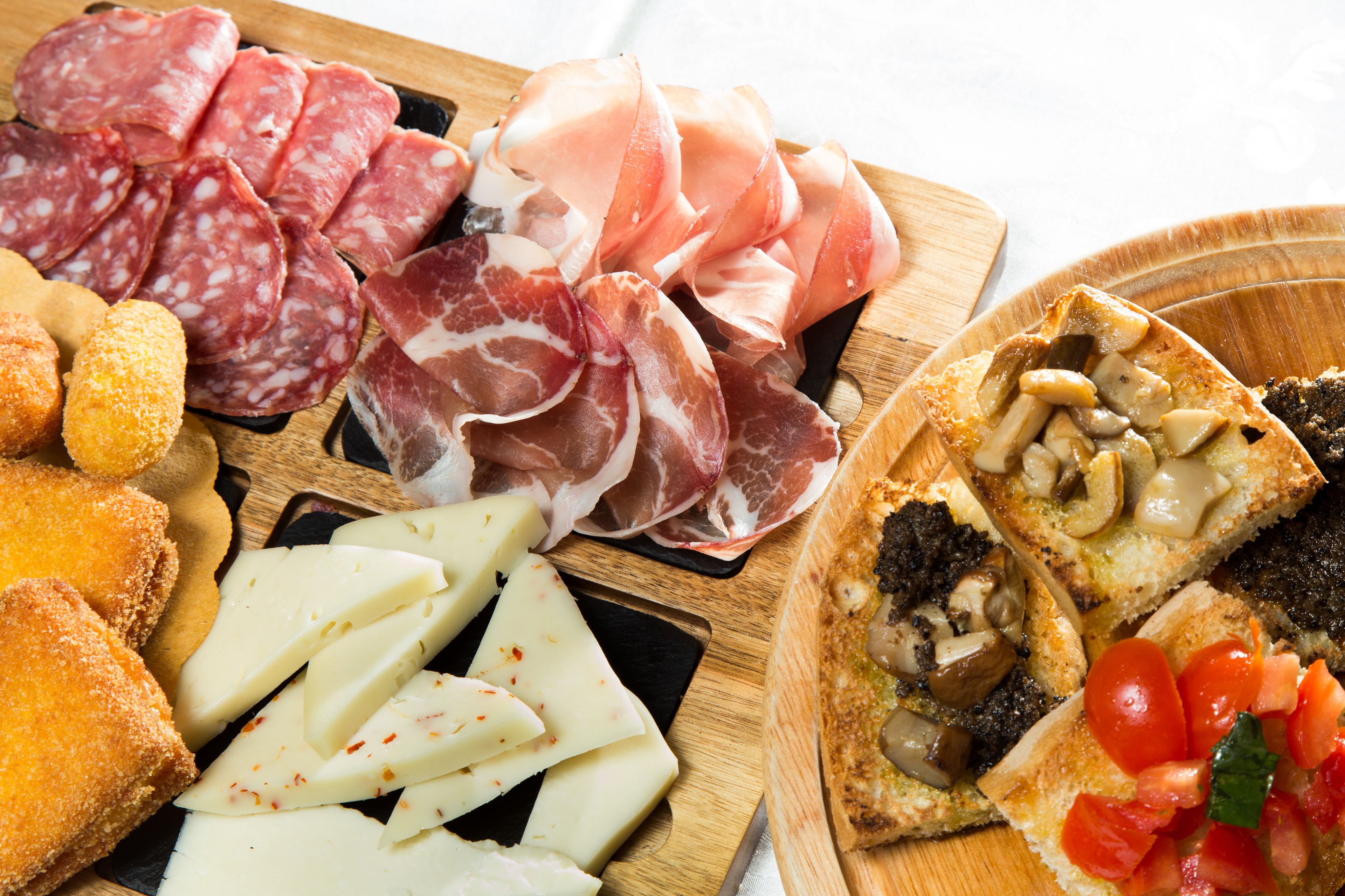 Een charcuterieplank met diverse vleessoorten, kazen en brood.