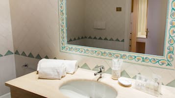Ein Badezimmer mit Waschbecken, Spiegel und Toilettenartikeln.